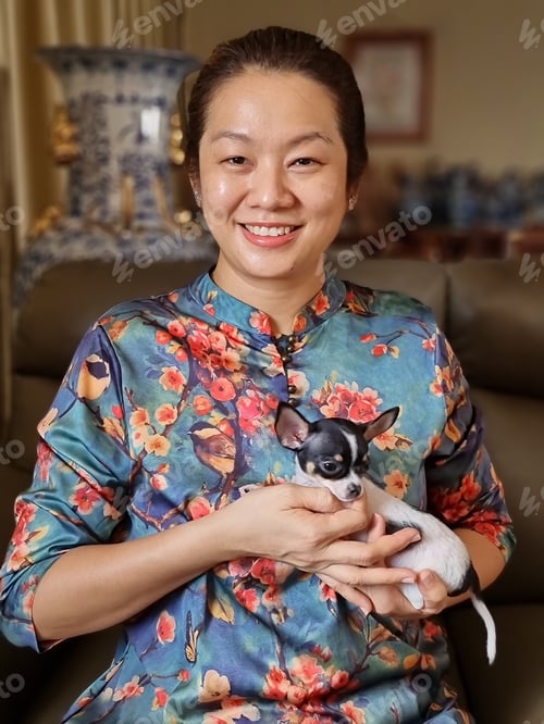 Preview: Portrait of an Asian woman holding her cute pet chihuahua puppy