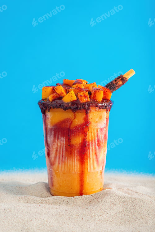 Preview: Mangonada, typical mexican mango smoothie on summer background.