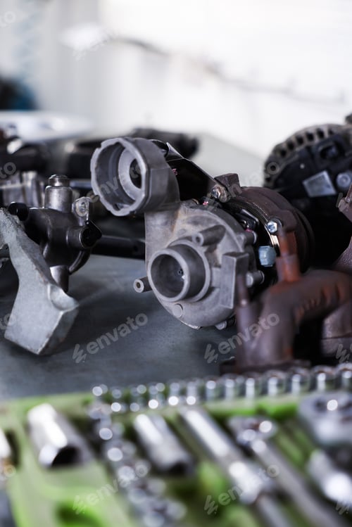 Preview: Different auto parts and tools on grey table indoors, closeup