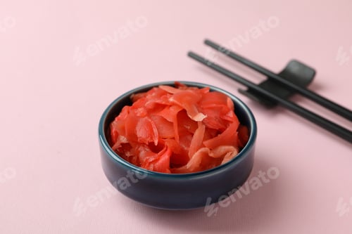 Preview: Bowl with red pickled ginger and chopsticks on pink background