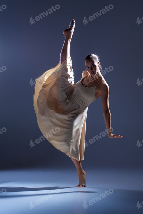 Preview: Young Beautiful Dancer In Beige Dress Dancing On Gray Studio Background