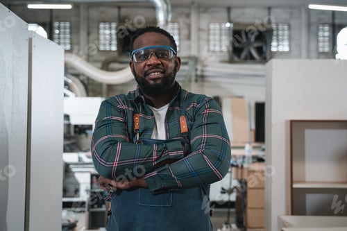 Preview: Portrait of Carpenter making woodworks handcrafted furniture in wood workshop.