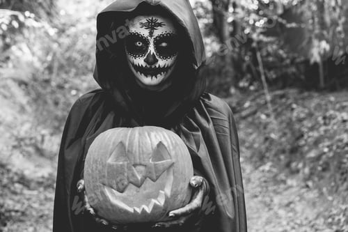 Preview: Young girl wearing mysterious Halloween dress holding scary pumpkin