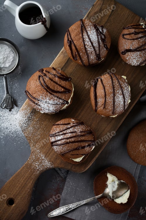 Preview: Chocolate cookies of Woopie Cookie with mascarpone cream on a gray dark concrete background. Selecti