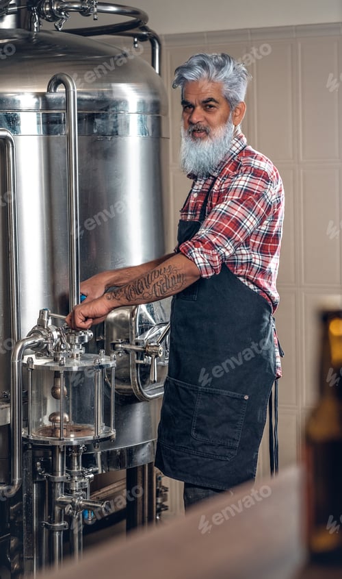 Preview: Old man dressed in apron working in modern brewery