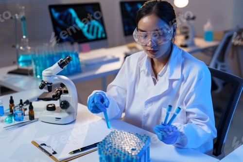 Preview: Female scientist wearing protective glasses and gloves, analyzing samples in a modern laboratory fil