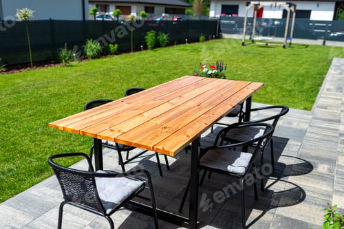 Preview: A modern table made of raw wood covered with yacht varnish, standing on the garden terrace.