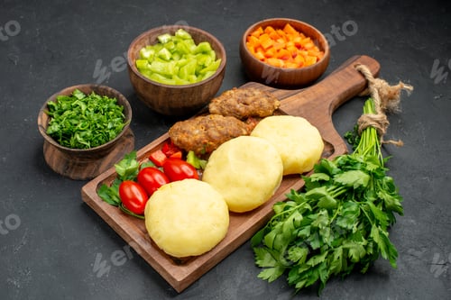 Preview: Side view of dinner background with tasty cutlets vegetables and greens on dark background
