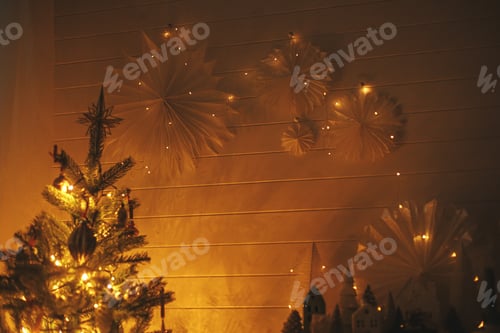 Visualização: Estrelas de Natal iluminadas com luzes douradas na parede à noite. Quarto escandinavo decorado