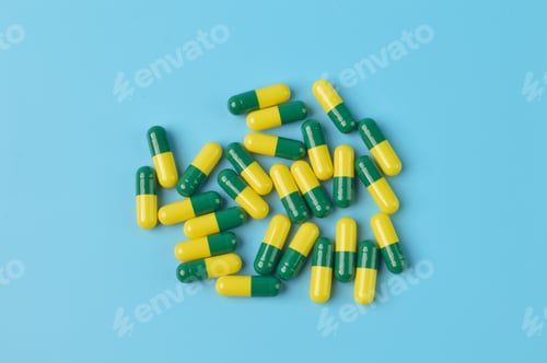 Preview: Bunch of pill capsules isolated on a blue background.