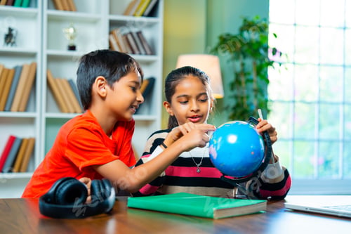 Preview: Indian Boy and Girl Siblings Playing with Educational Globe at Home – Geography Learning Concept