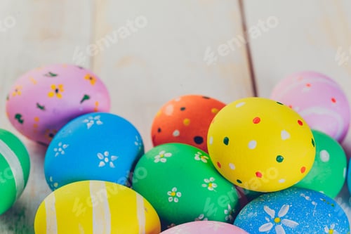 Preview: Easter eggs painted in pastel colors on white wooden background.