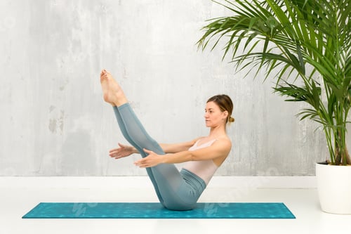 Preview: Fit healthy woman doing a Navasana Yoga Pose or Boat Pose