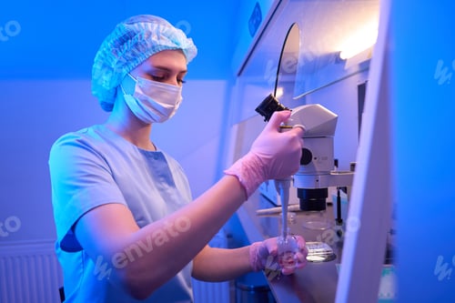 Preview: Focused female scientist aspirating reagent from vial