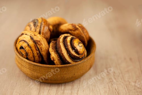 Preview: Cinnabon cinnamon buns in a wooden bowl on a beige background. Sweet food baking. Cinnabons cake.