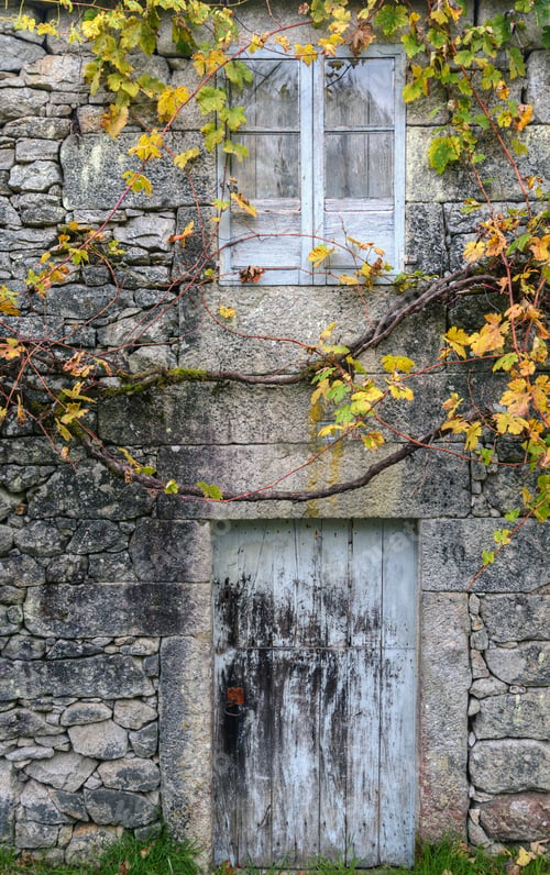 Preview: Front of an old rural stone house with the typical arbor