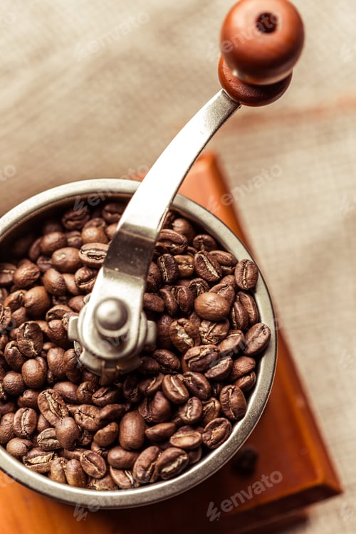 Preview: Grinding fresh coffee beans in a traditional coffee grinder for aromatic brew preparation