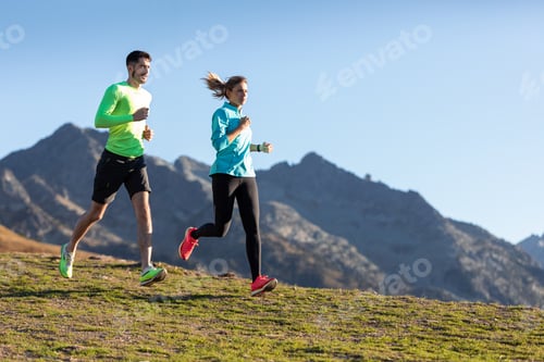 Preview: Healthy young couple running on mountain trail in the morning.
