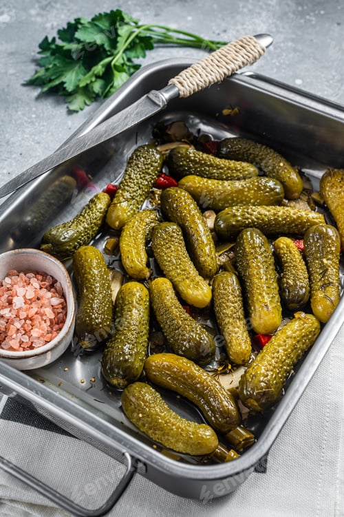 Preview: Homemade marinated pickled cucumbers with dill, garlic and spices in big kitchen tray.