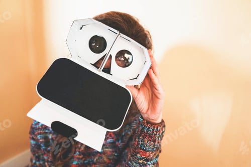 Preview: Image of a young woman showing the inside of a cardboard vr glasses