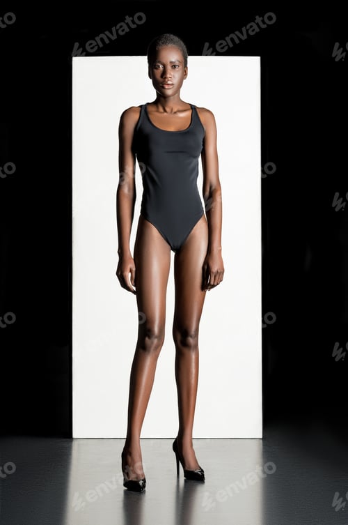 Preview: full length view of beautiful young african american woman in bodysuit and high heeled shoes looking