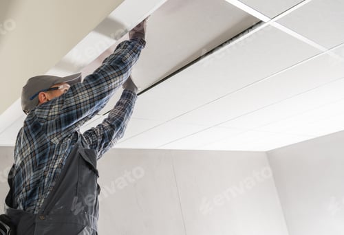 Trabajador de una obra de construcción instalando un techo suspendido