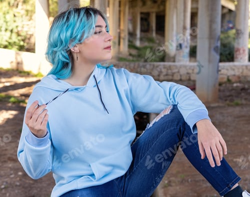 Preview: Blue haired Teenage girl in light blue oversize hoodie sitting under bridge