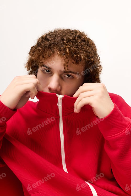 Preview: Stylish teenager shows off fashion sense with a bold red zip up in creative pose