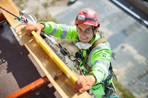 Preview: Industrial climber measuring with level tube during construction works