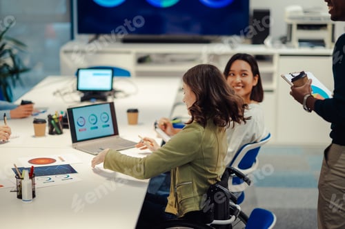 Preview: Business woman who uses a wheelchair while using a laptop during a meeting