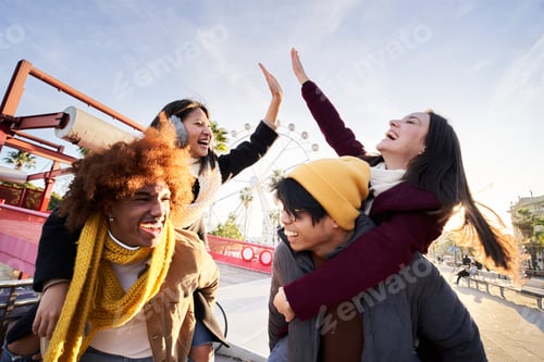 Preview: Cheerful two couple walking outdoors in a theme park and having fun celebrating high five