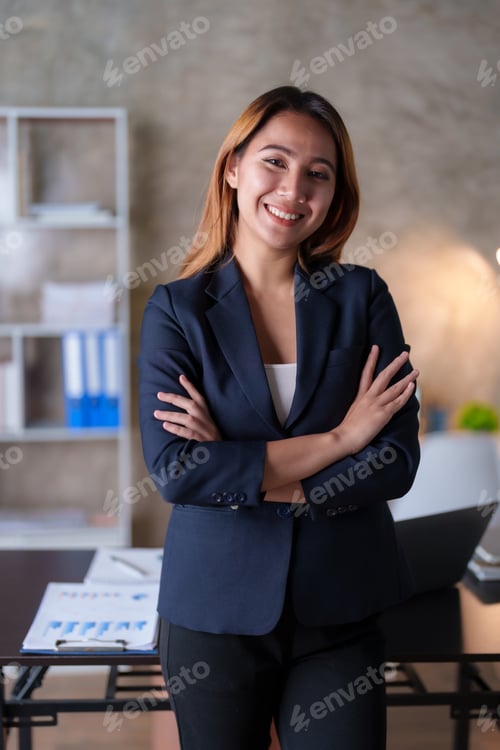 Preview: Asian businesswoman standing with her arms crossed and confidently looking at the camera and focused
