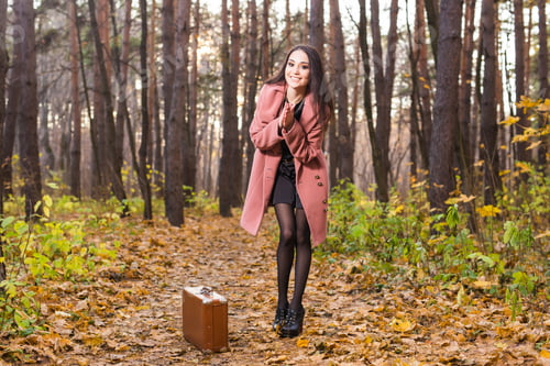 Preview: Fall, season and people concept - charming woman standing in park at autumn