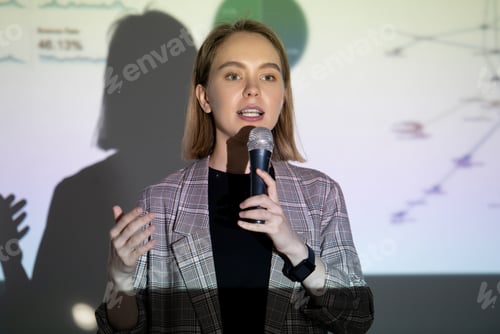 Confident young woman speaking into microphone