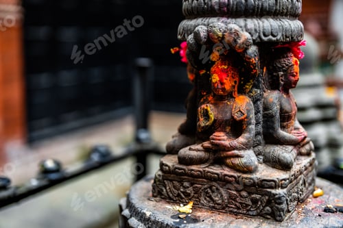 Preview: Black Buddha idol statue with red orange yellow colored powder in Durbar Square, Nepal