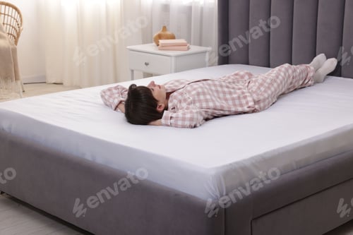 Preview: Beautiful woman lying on soft mattress at home
