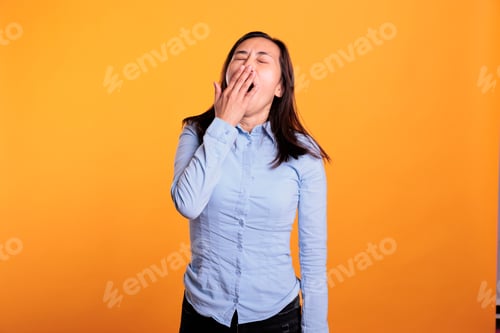 Preview: Portrait of sleepy filipino woman covering mouth with hand