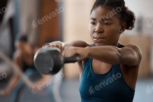 Preview: Cropped shot of an attractive and athletic young woman working out with a kettle bell in the gym