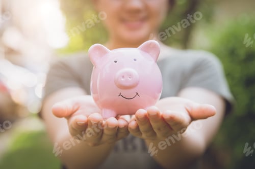 Preview: closeup happy smile money saving piggy bank on girl hand.