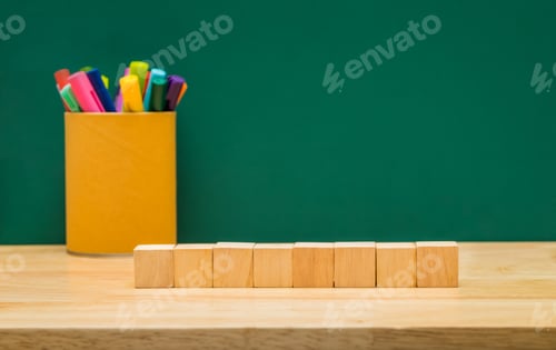 Preview: Black wood cube with colorful pen box on wood table with green blackboard wall