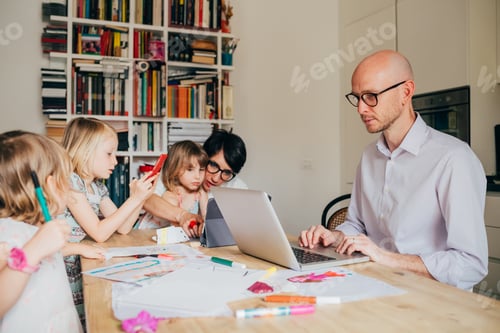 Preview: Parents indoor sitting table homeschooling with three female children