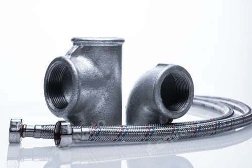 Preview: steel pipe fittings on a white background. metal tee, corner and two reinforced hoses.
