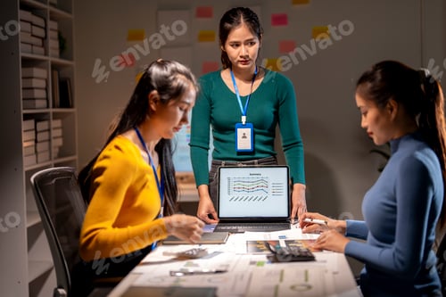Preview: Three women are sitting at a table with a laptop open in front of them