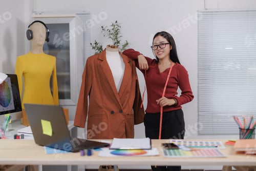 Preview: Fashion designer measuring clothes on mannequin in creative office