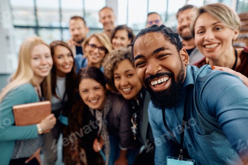 Preview: Group of happy entrepreneurs taking selfie while attending business conference at convection center.
