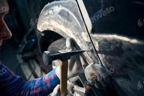 Preview: Skilled worker working with front fender with instrument