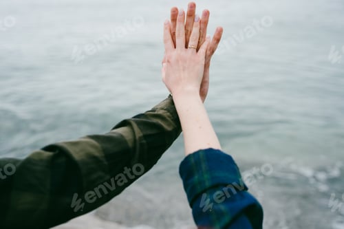 Preview: Two hands of a guy and a girl in love on the background of the sea.
