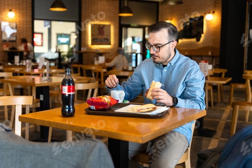 Preview: Young man enjoying casual lunch at restaurant