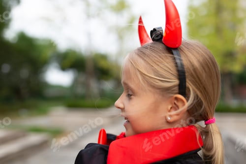 Preview: Happy kid in evil costume celebrating Halloween 2020 during coronavirus covid-19 pandemic