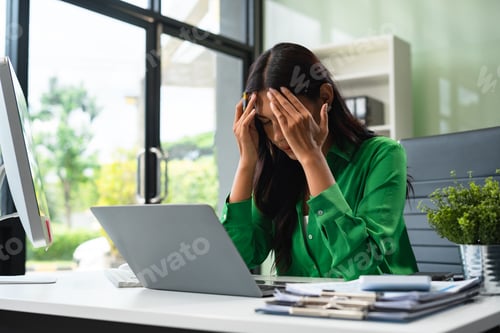 Preview: Stress businesswoman is sitting at table, under stress from working.